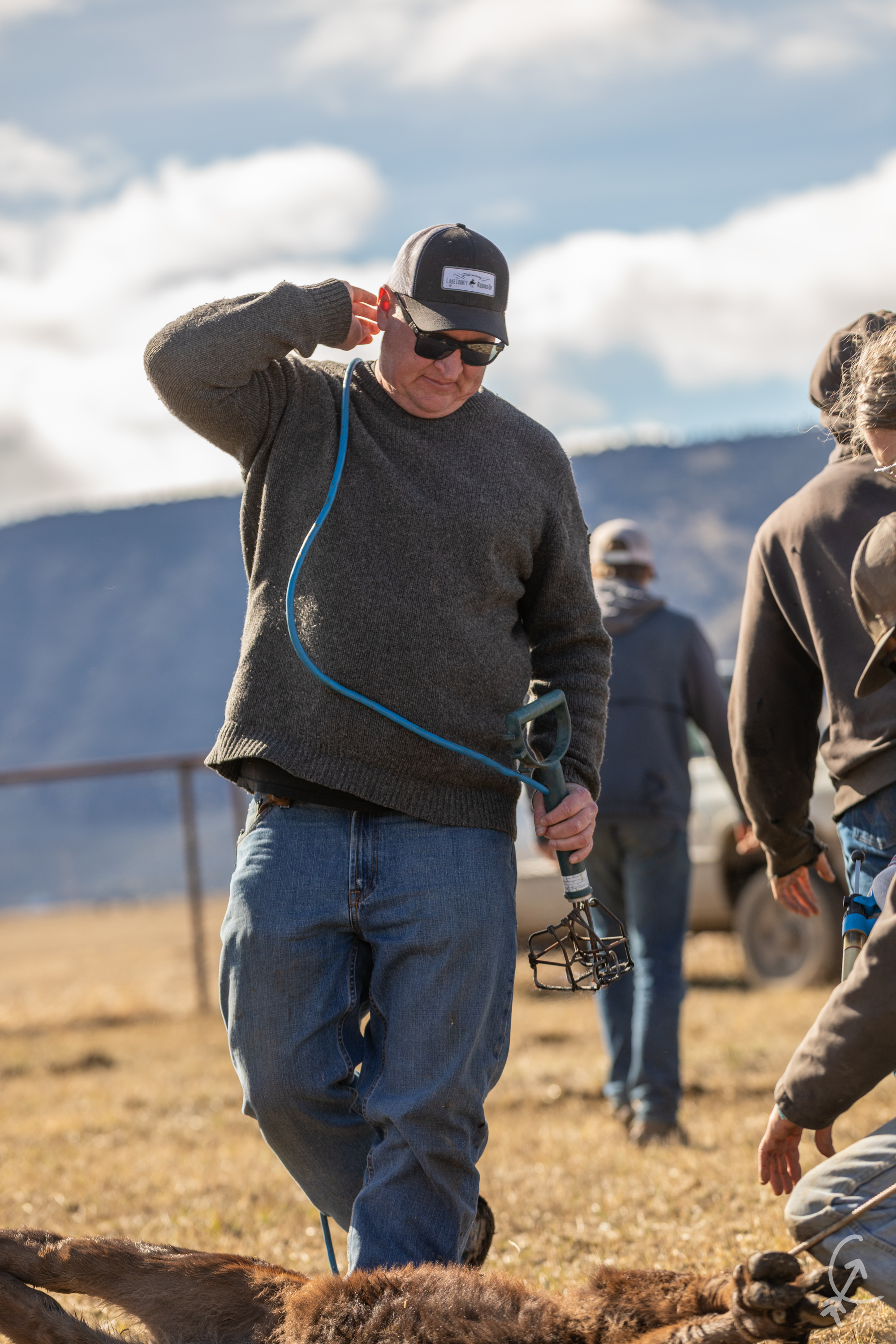 Richard Bradbury handling cattle equipment alongside the ranch crew